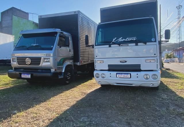 Dois caminhões baú da Martins Fretes e Mudanças estacionados, prontos para mudança